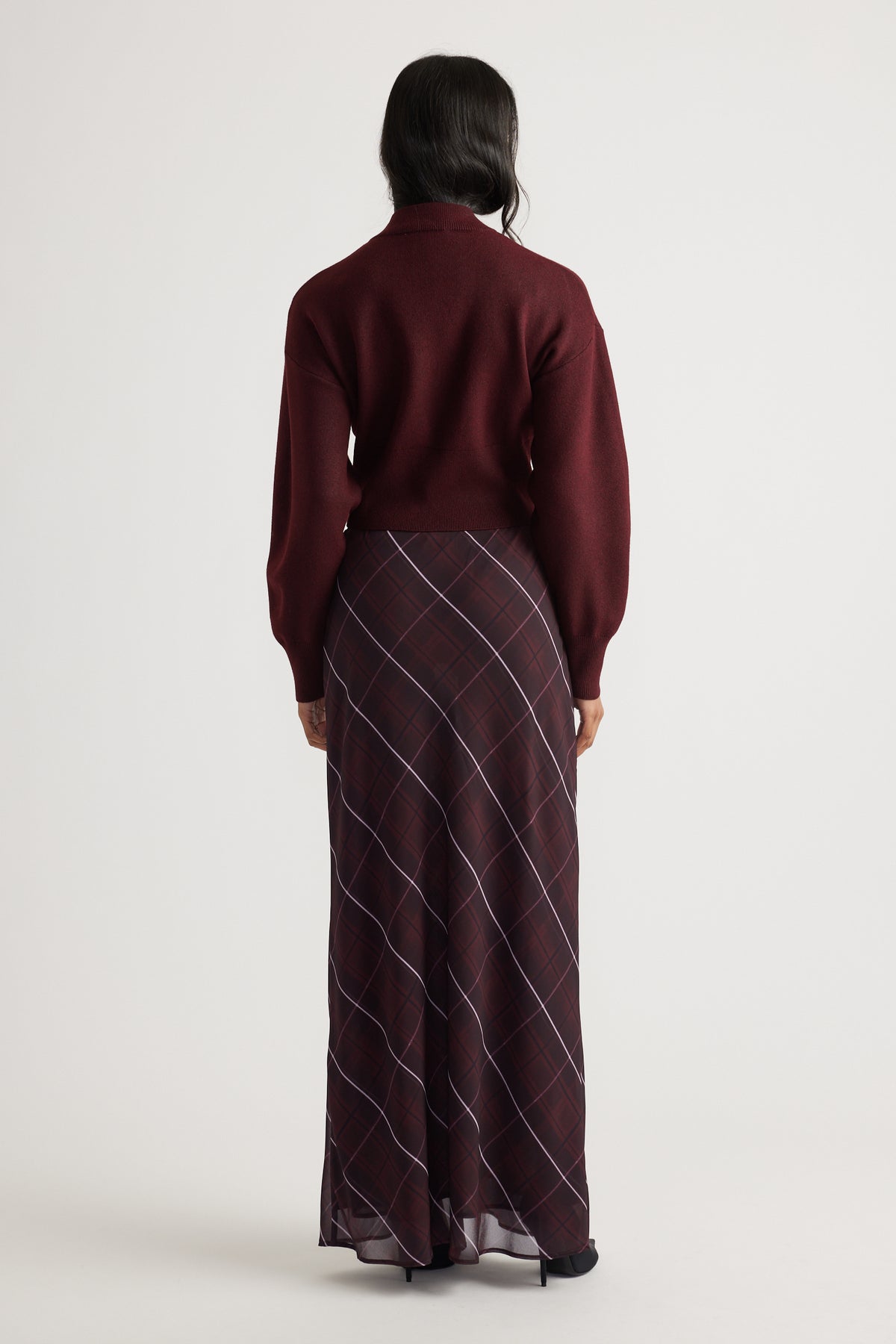 Back view of Zoey Zip Knit Jumper in deep burgundy paired with a flowy plaid maxi skirt by Decjuba Australian brand