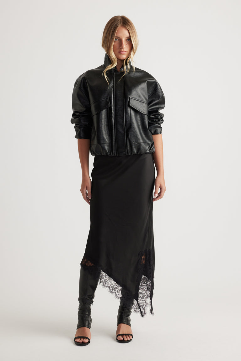 Karla Lace Slip Skirt with lace-trimmed asymmetric hem styled with a black leather jacket and heeled sandals by DECJUBA