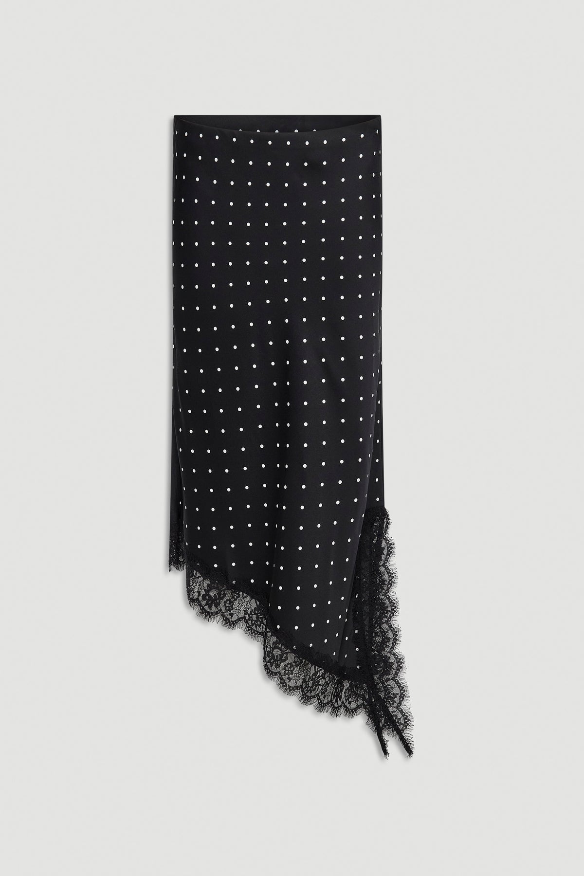 Black midi skirt with white polka dots, asymmetric lace-trimmed hem, and side slit detail against white background