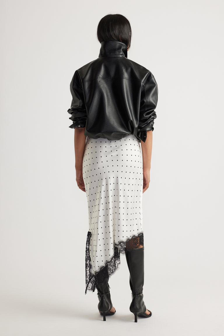 Woman wearing Karla Lace Slip Skirt in ivory with black polka dots and delicate lace trim, styled with black leather jacket and boots