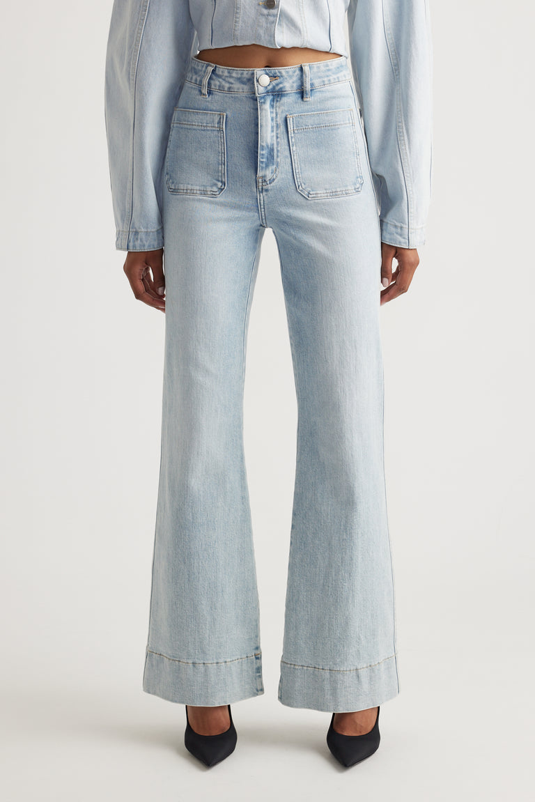 Front view of Tori Flare Jean in light denim with wide hem and front pockets styled by Decjuba Australian brand