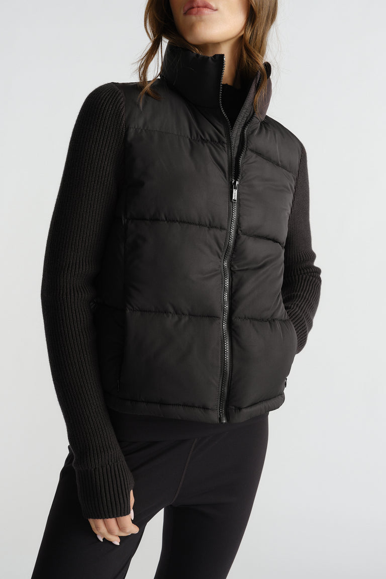 Black quilted knit puffer jacket with zip front and ribbed long sleeves for a cozy yet stylish cold-weather layer.