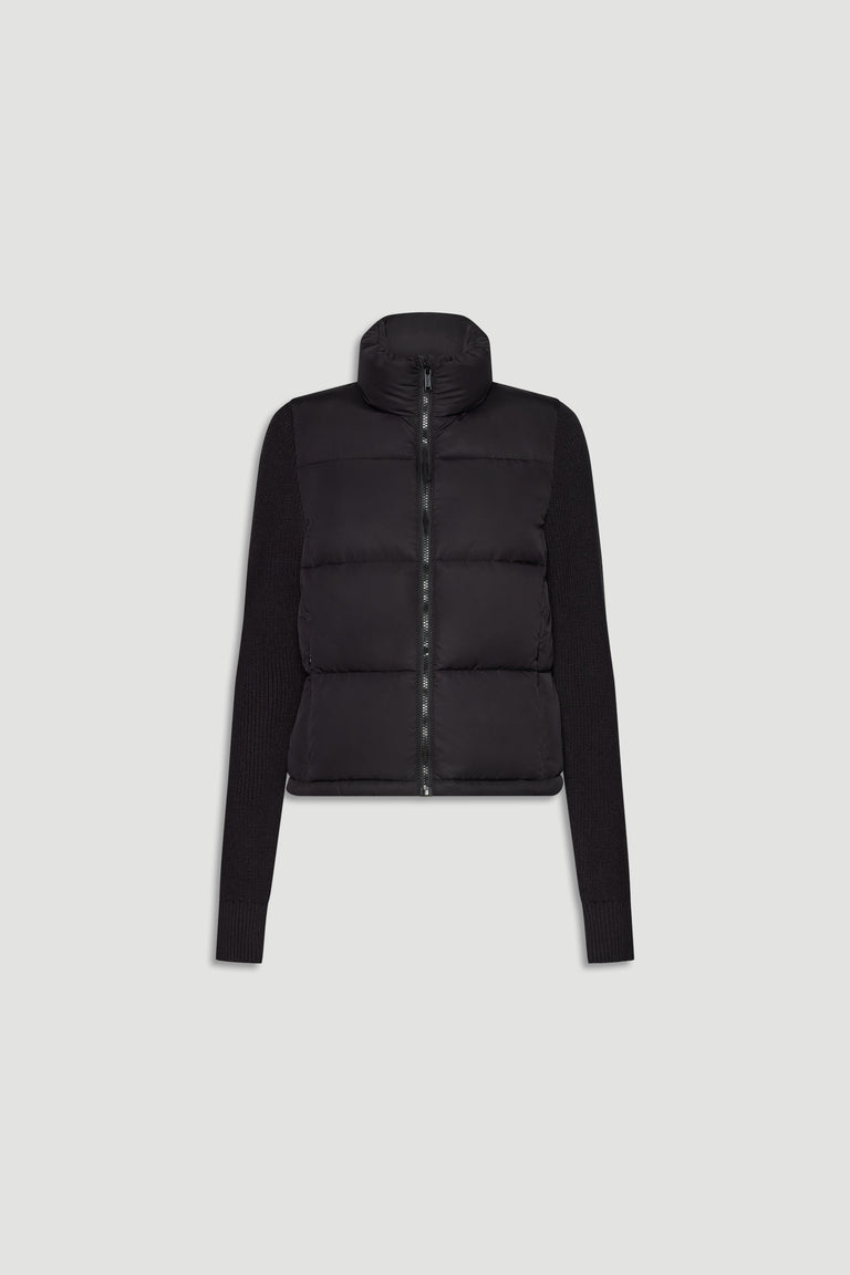 Black knit puffer jacket with padded front and ribbed long sleeves, featuring a high collar and front zip closure.