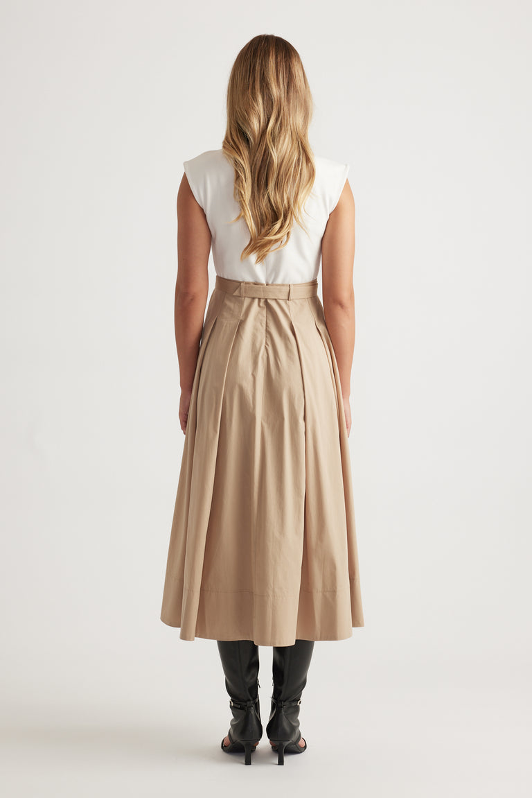 Rear view of Stefanie Spliced Midi Dress in tan with pleated skirt detail and concealed back zipper, styled with black boots