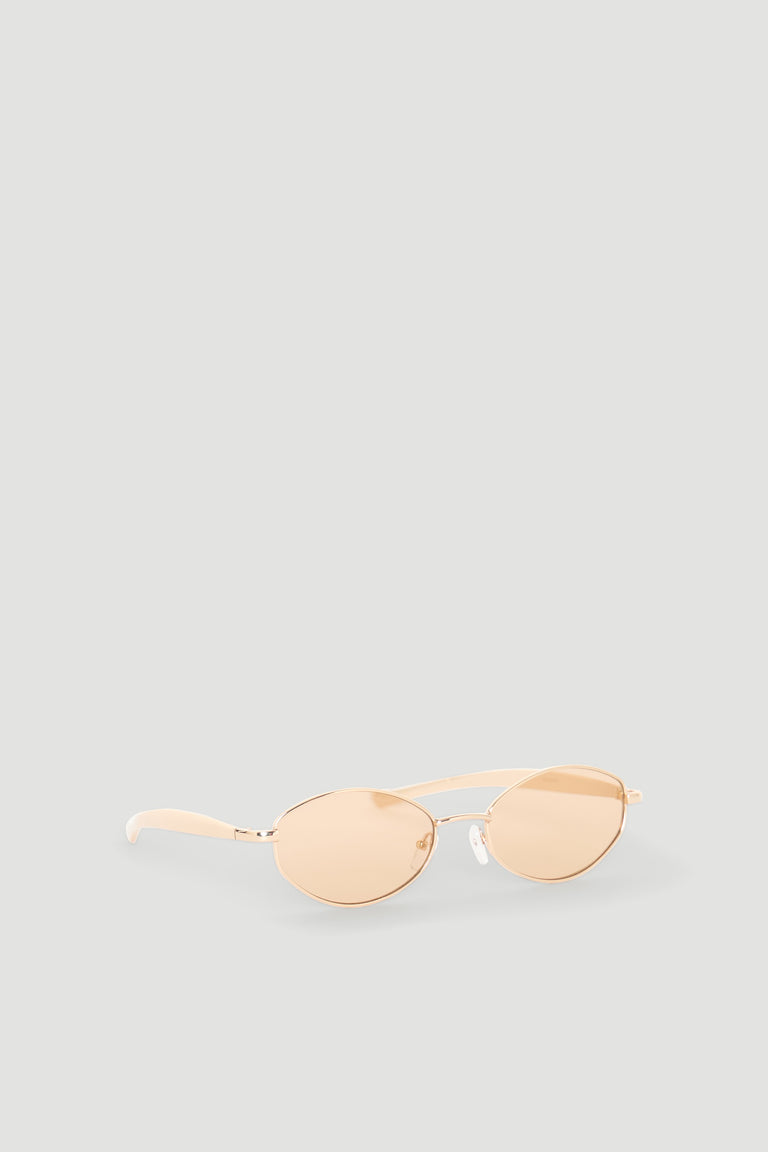 Slim oval sunglasses with gold metal frames and warm tinted lenses for a stylish, modern accessory.