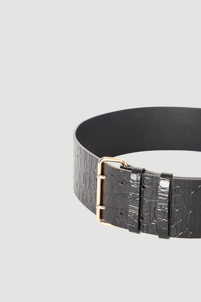 Close-up of a black wide belt with embossed texture and a polished gold-tone buckle against a neutral background