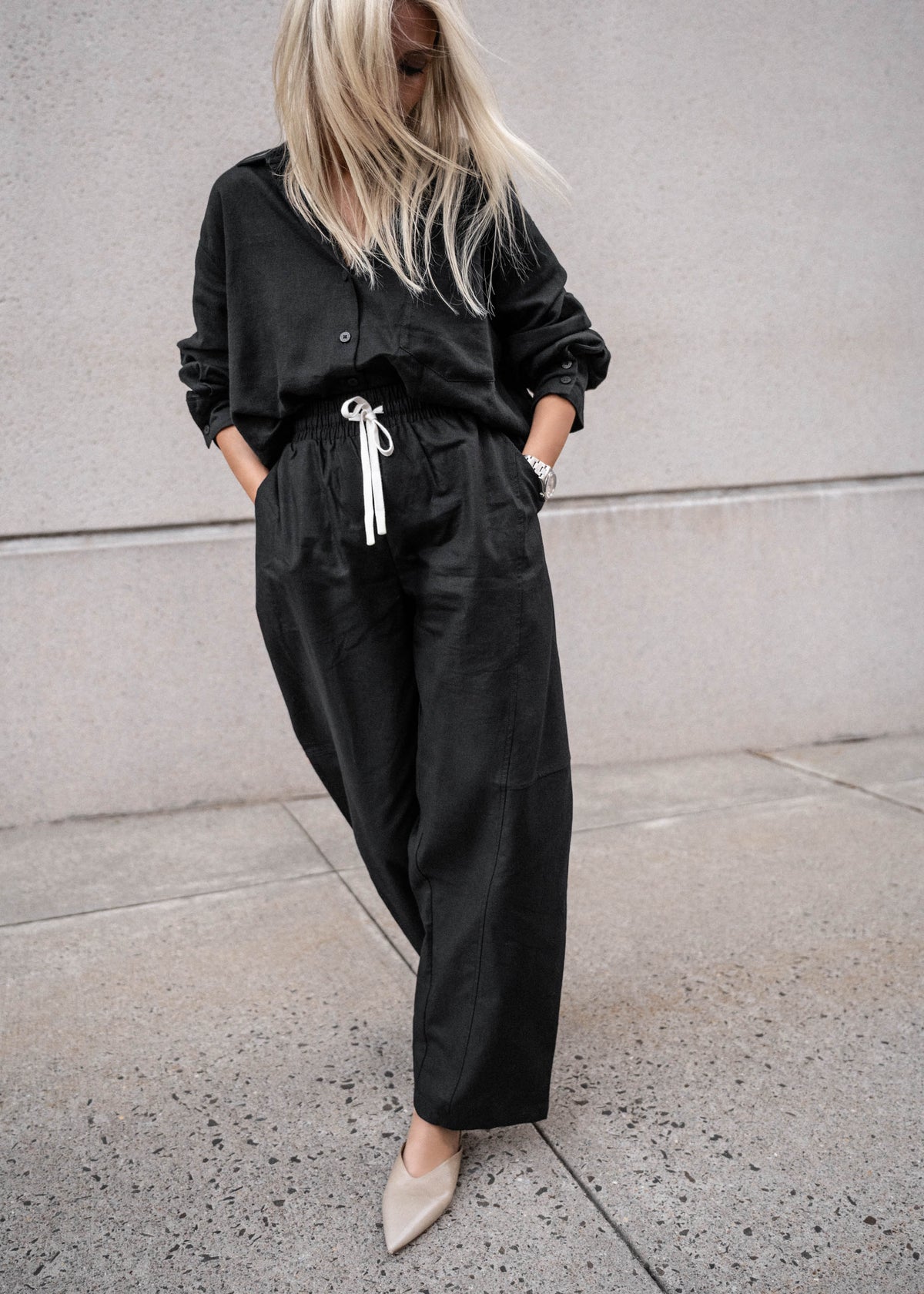 Woman wearing black D-Luxe Linen Blend LS Shirt styled casually, gallery position 5, portrait orientation, urban background.