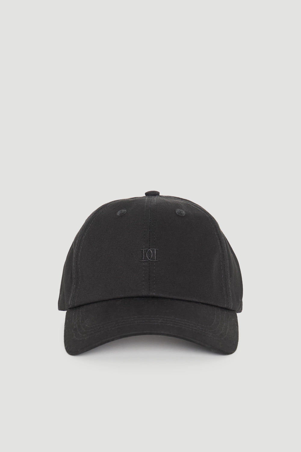 Minimalist black cap with subtle tonal logo embroidery for a sleek, versatile everyday accessory.