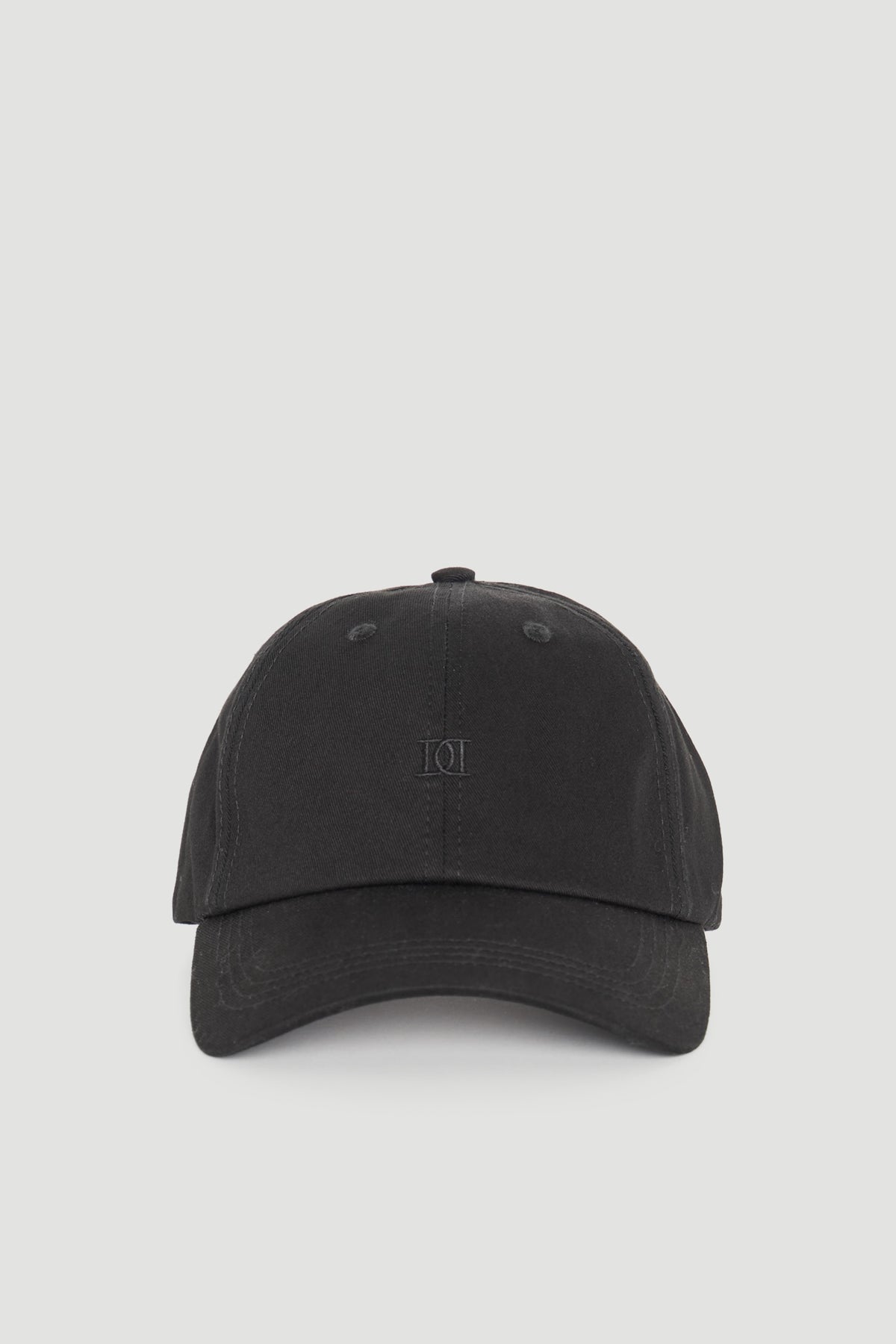 Minimalist black cap with subtle tonal logo embroidery for a sleek, versatile everyday accessory.