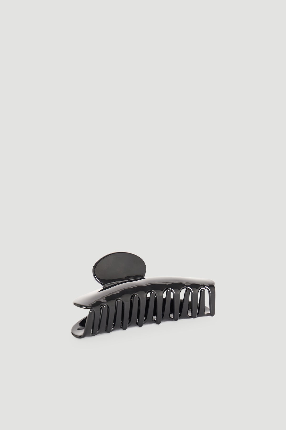 Sleek black hair claw clip with curved design for easy and stylish hair styling and secure hold