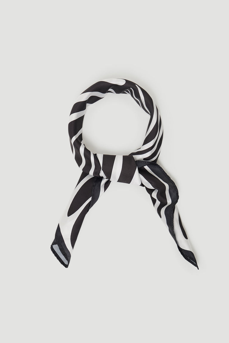 Black and white striped scarf loosely tied in a smooth fabric with a subtle sheen against a light background