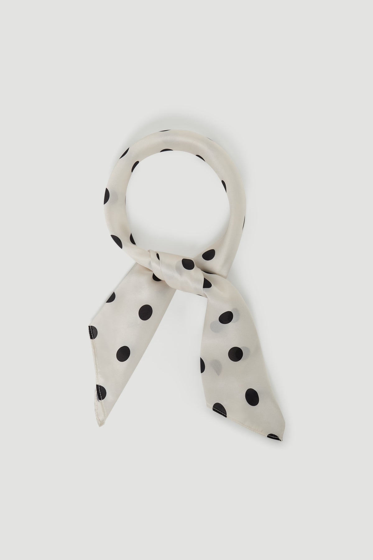 Polly Scarf in portrait view, lightweight with smooth texture and black polka dots on white fabric, gallery position 1.
