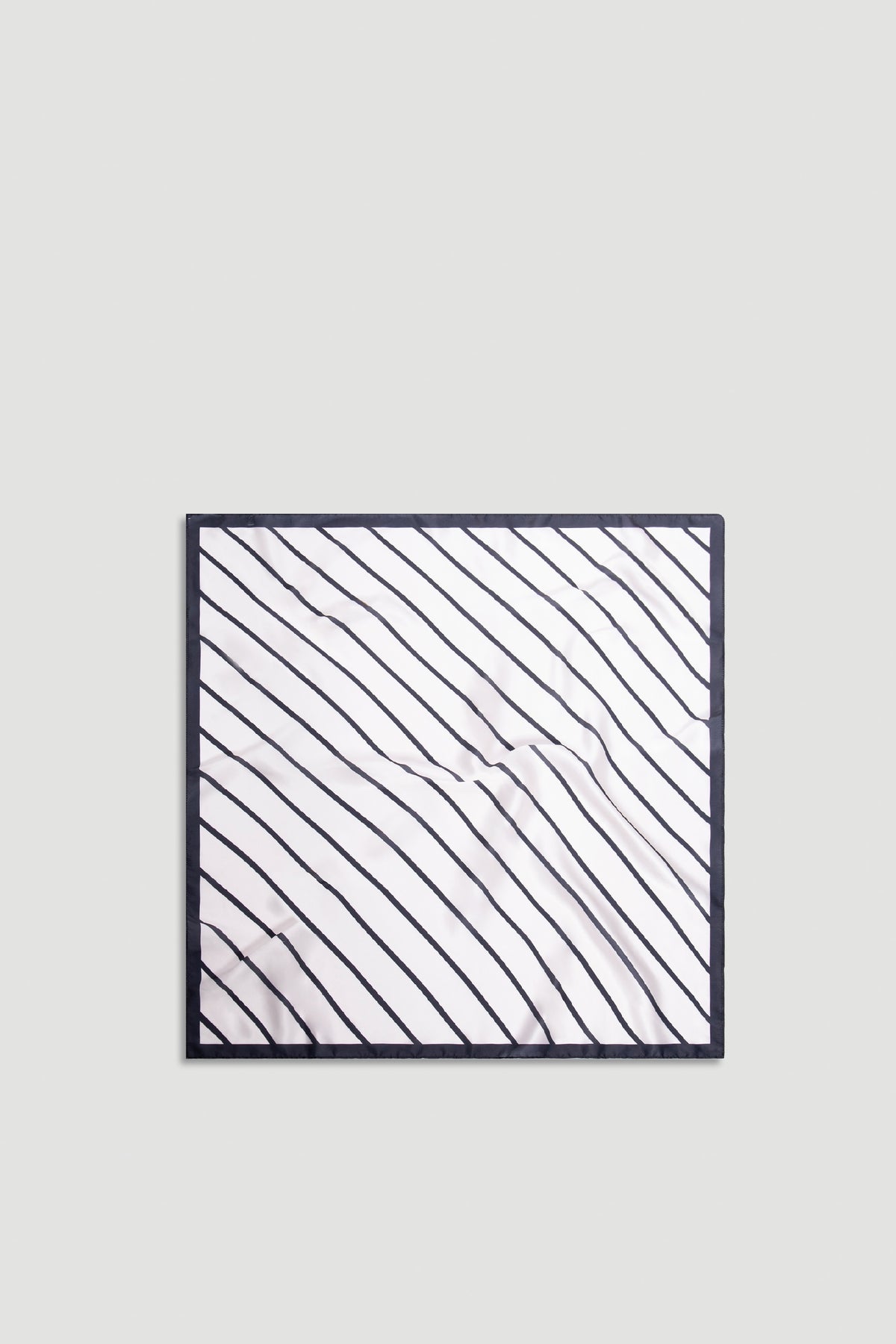 Polly Scarf in soft fabric with diagonal black stripes and solid black border for a chic, timeless accessory.