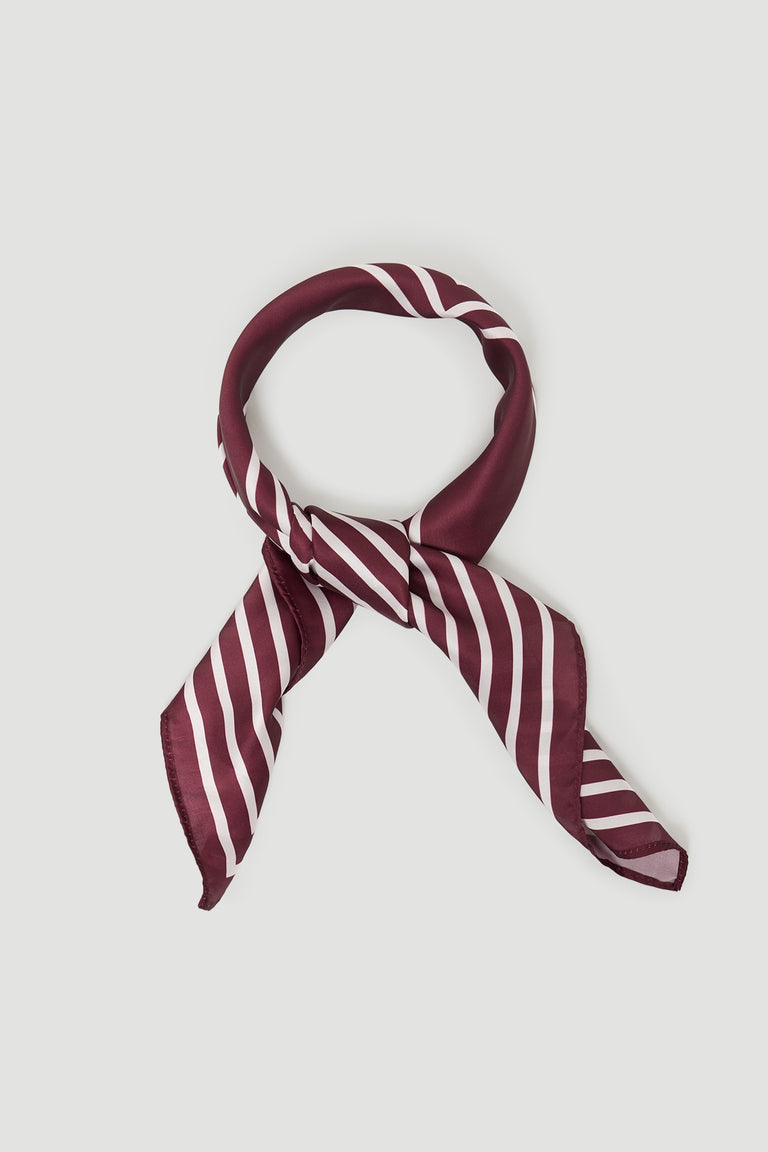 Silky plum scarf with white diagonal stripes, styled in a loose knot for a chic and versatile accessory.