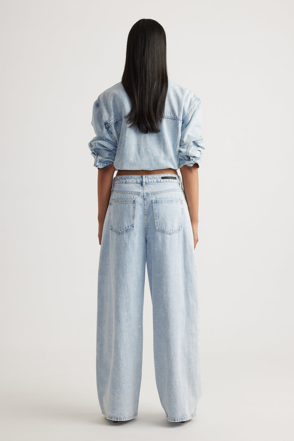 Rear view of Elena Wide Leg Jean in light denim styled with matching top by Decjuba Australian fashion brand