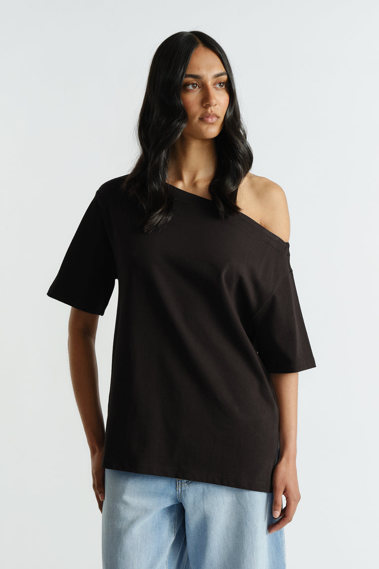 Woman wearing a black off-shoulder relaxed tee paired with light blue wide-leg denim jeans for a casual look