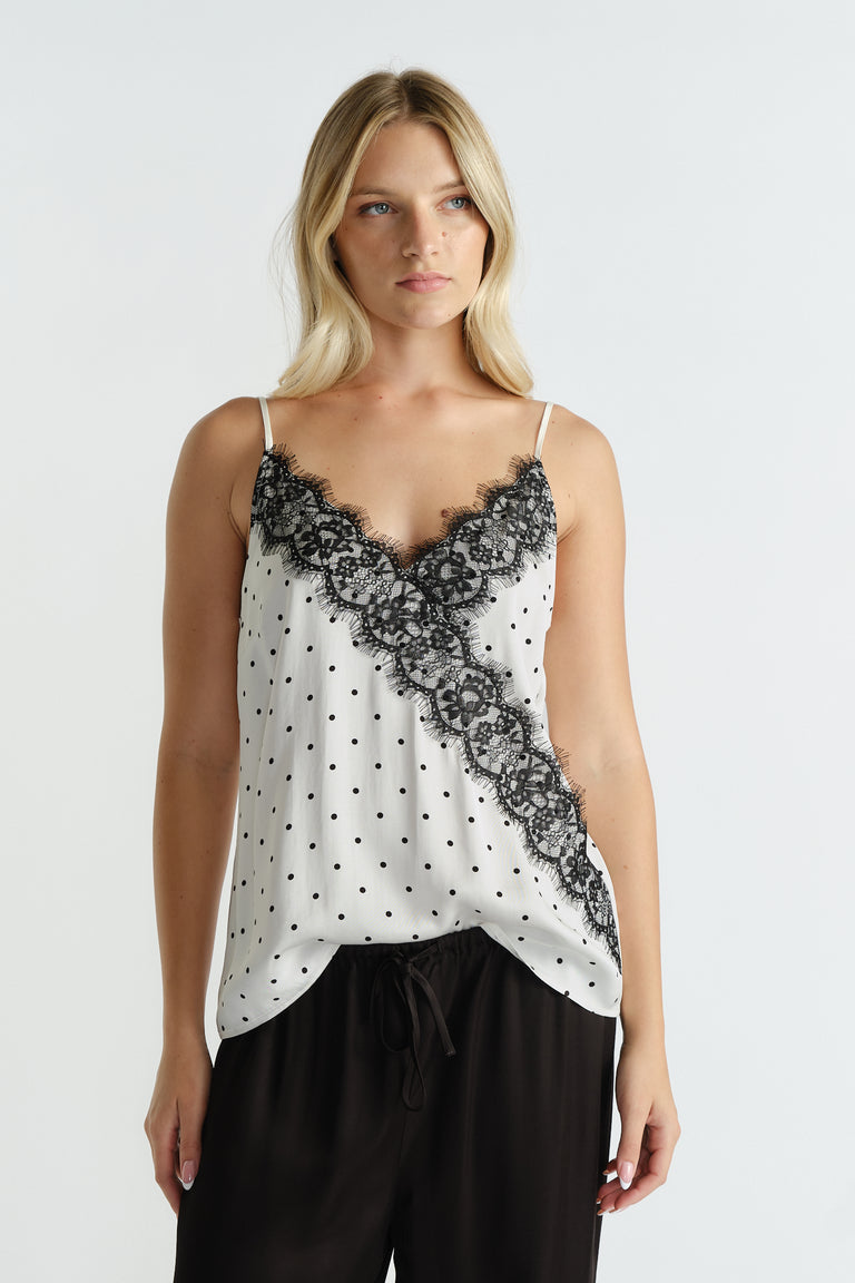 Ivory camisole with black polka dots and lace trim detail paired with relaxed black pants for an effortless look