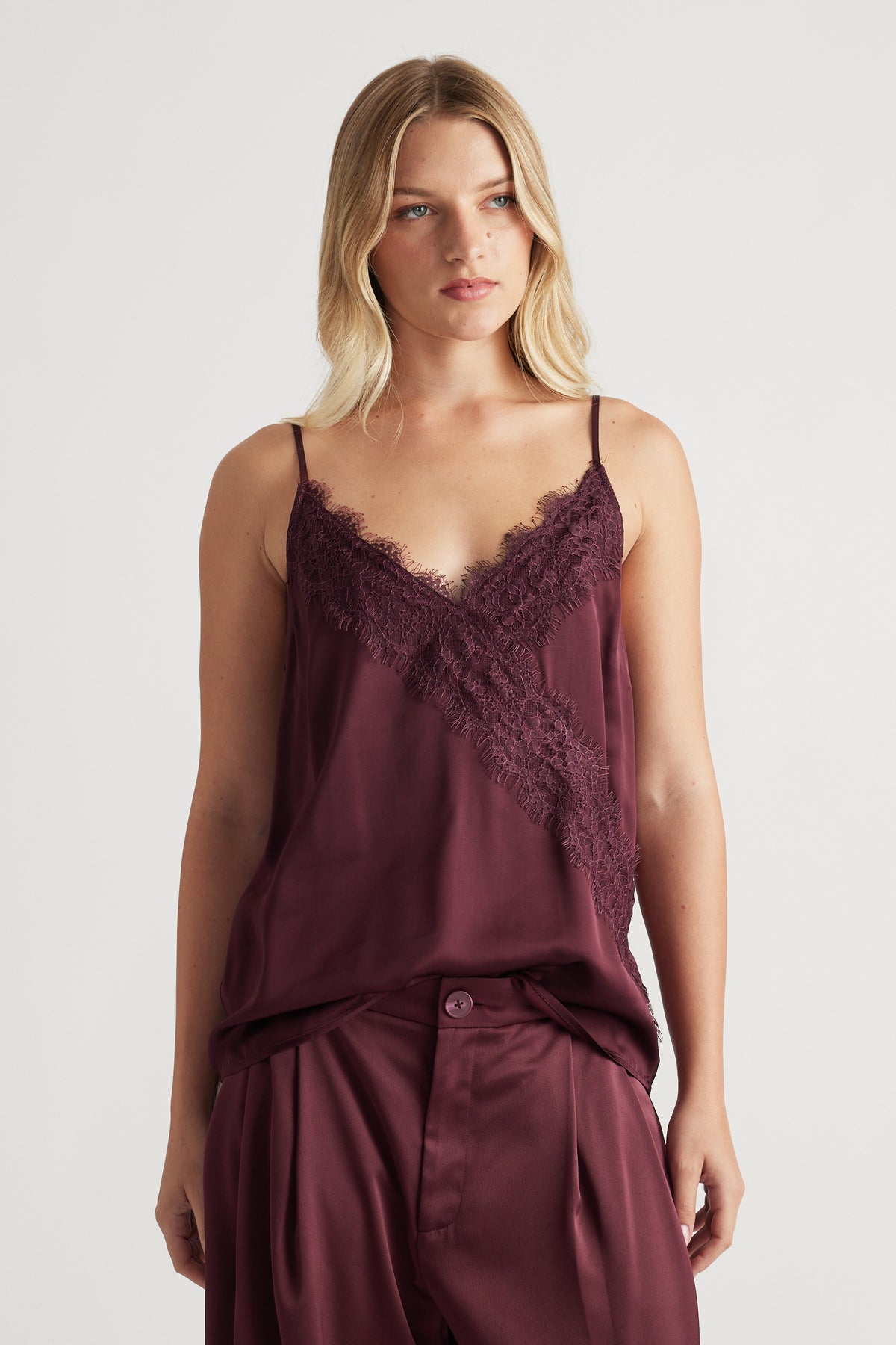 Woman wearing a plum lace-trimmed cami top paired with matching wide-leg pants for a relaxed, chic look