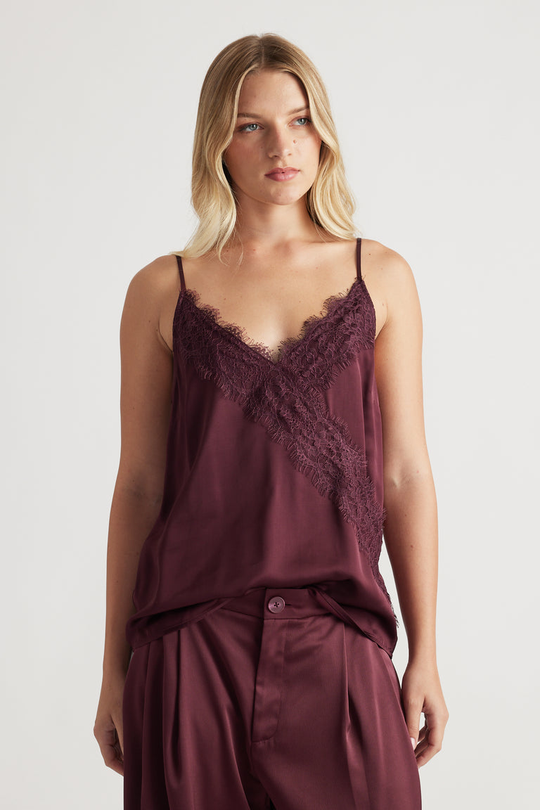 Woman wearing a plum lace-trimmed cami top paired with matching wide-leg pants for a relaxed, chic look