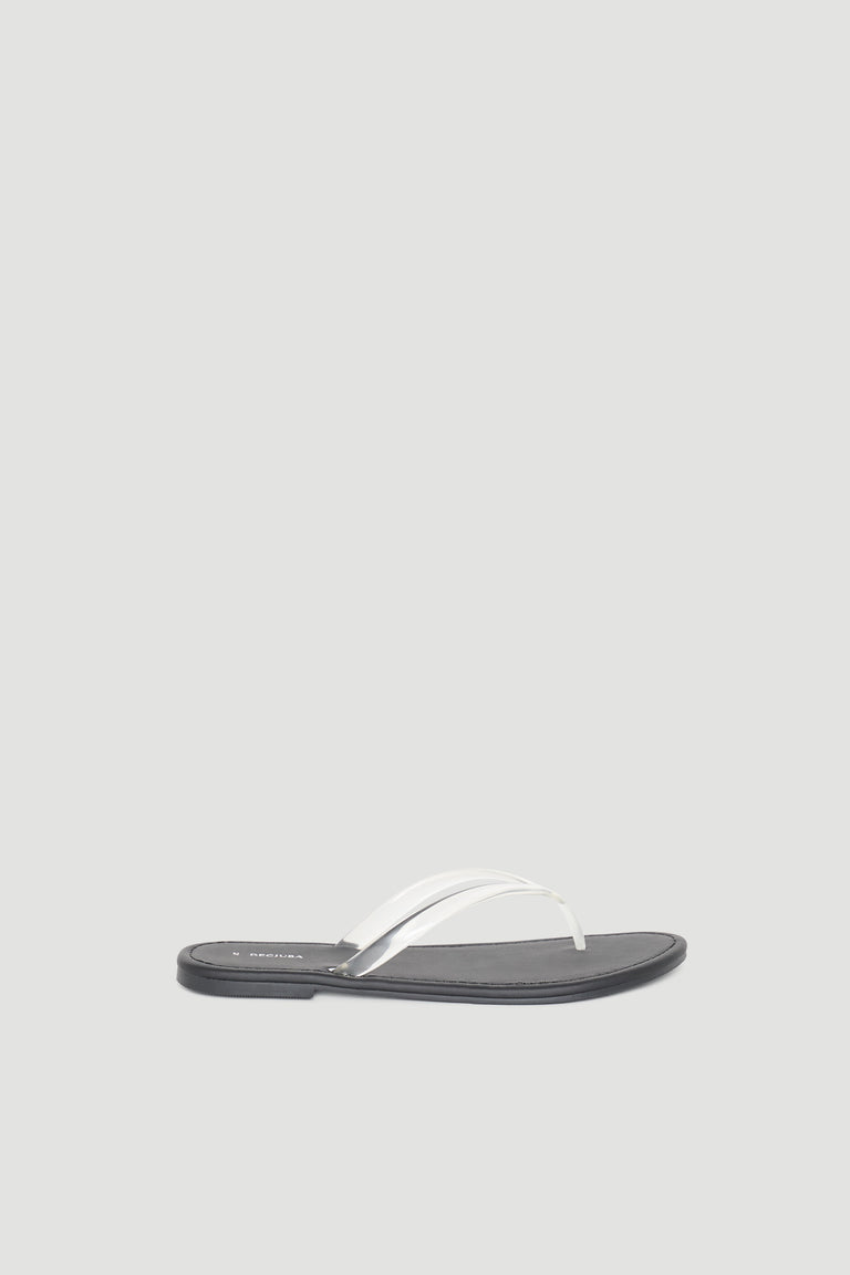 Minimalist black flat thong slide sandal featuring a sleek white strap for effortless everyday wear.