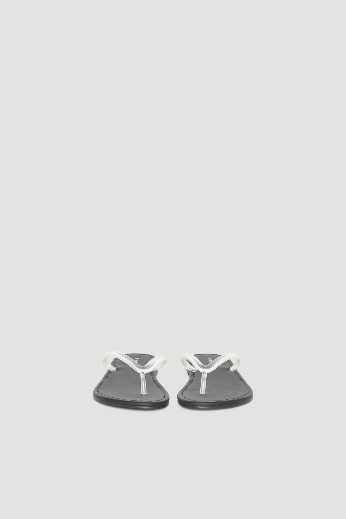 Minimalist black thong slides with sleek white straps, designed for casual everyday comfort and versatile style.