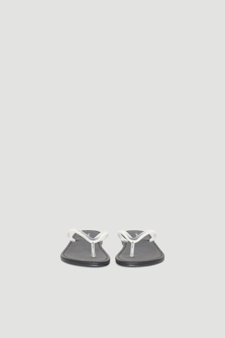 Minimalist black thong slides with sleek white straps, designed for casual everyday comfort and versatile style.