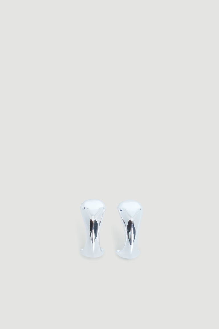 Polished silver abstract hoop earrings with smooth curved design on a light neutral background