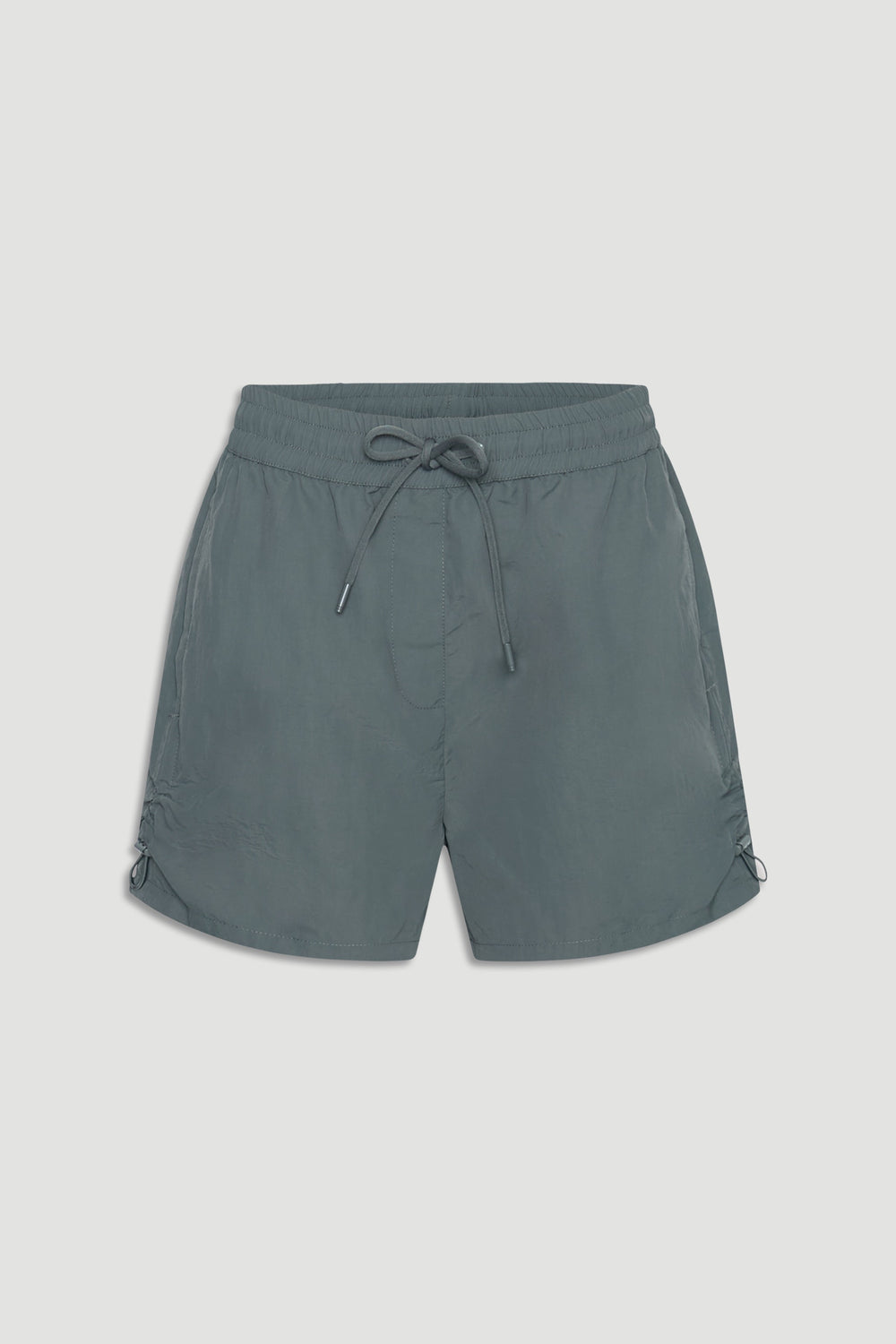 Lightweight nylon sport shorts in muted green with elastic waist and adjustable drawstrings for a casual athletic look.