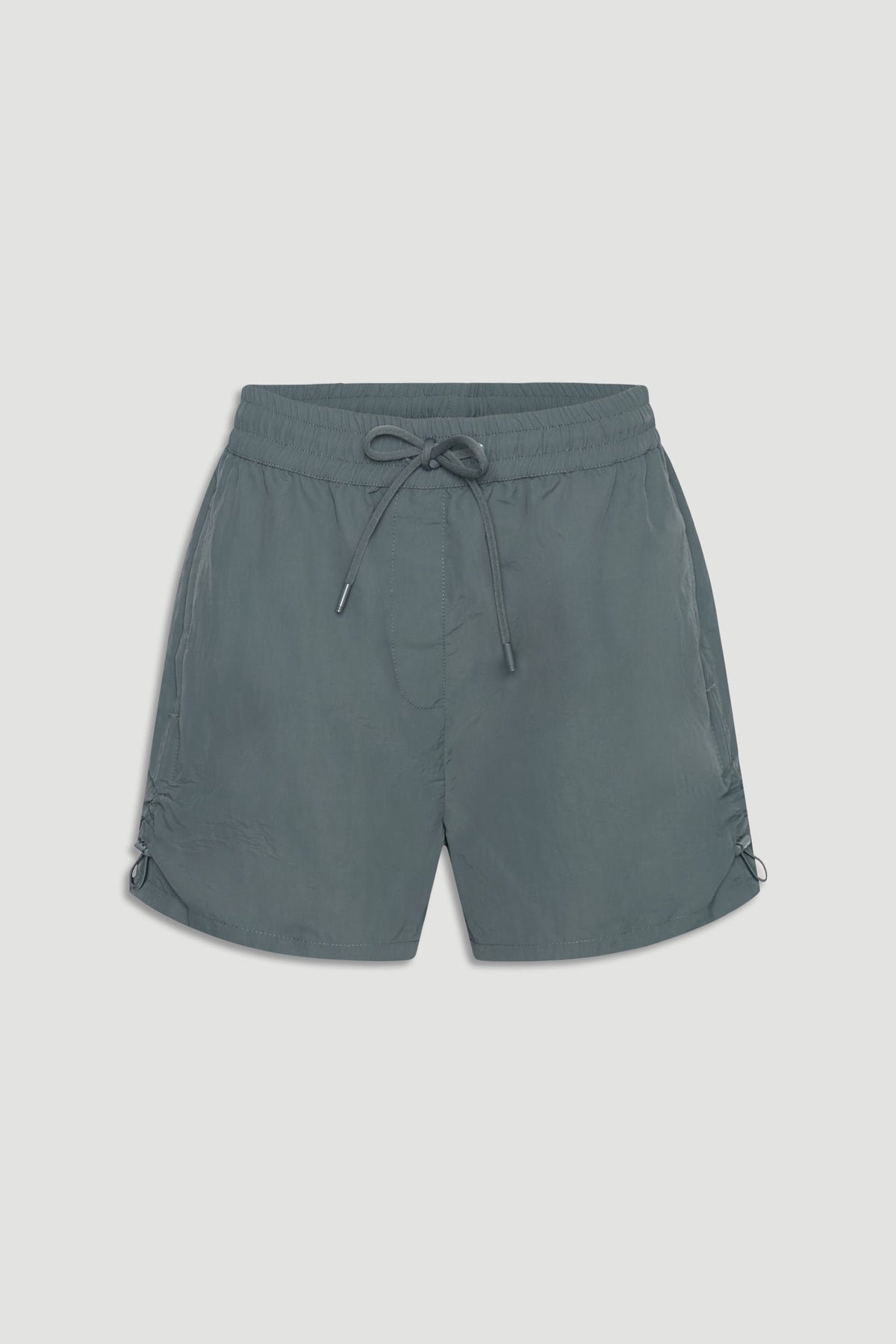Lightweight nylon sport shorts in muted green with elastic waist and adjustable drawstrings for a casual athletic look.