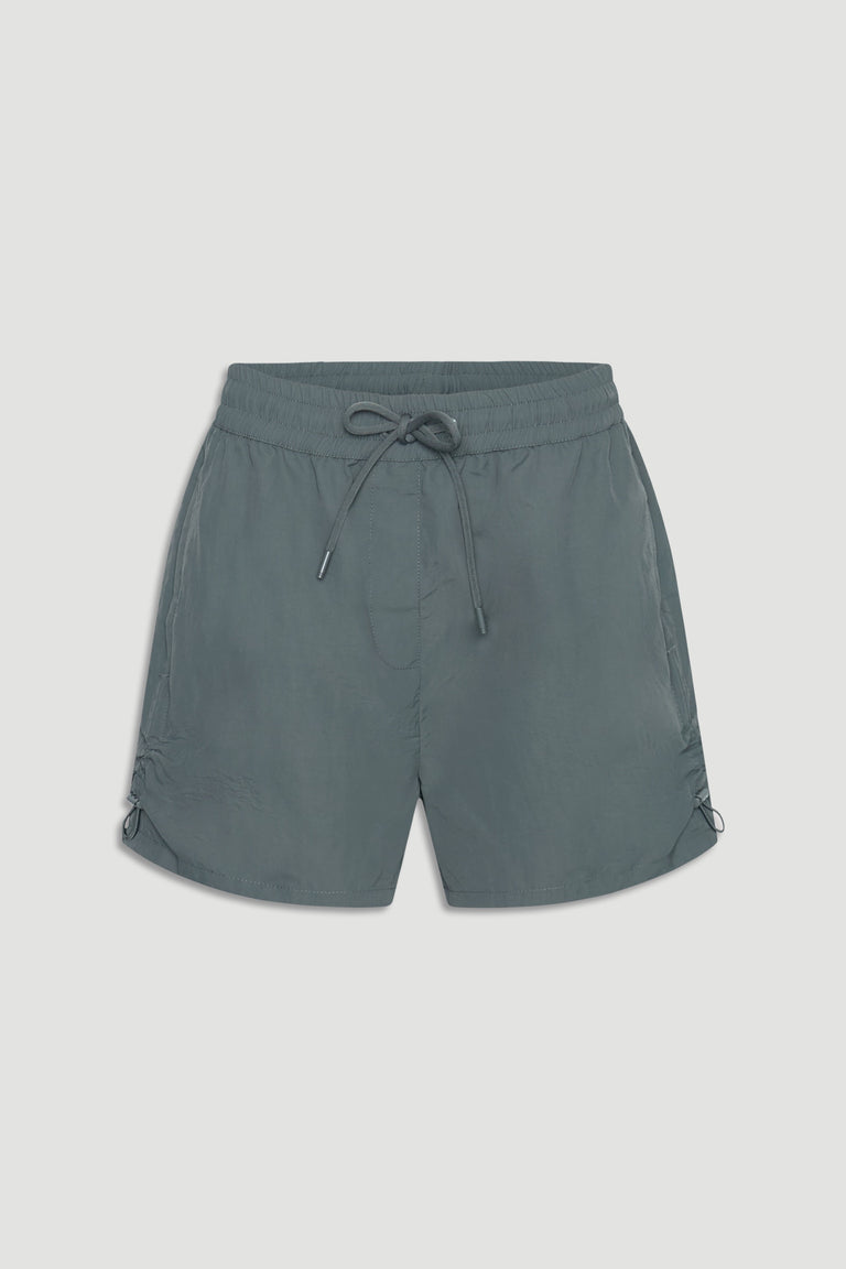 Lightweight nylon sport shorts in muted green with elastic waist and adjustable drawstrings for a casual athletic look.