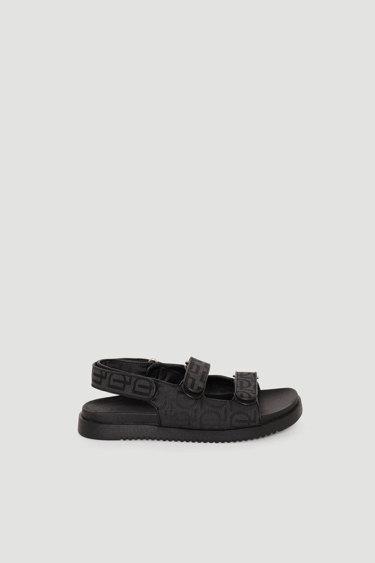 Black adjustable sandals featuring monogram straps and a cushioned sole for stylish everyday comfort.