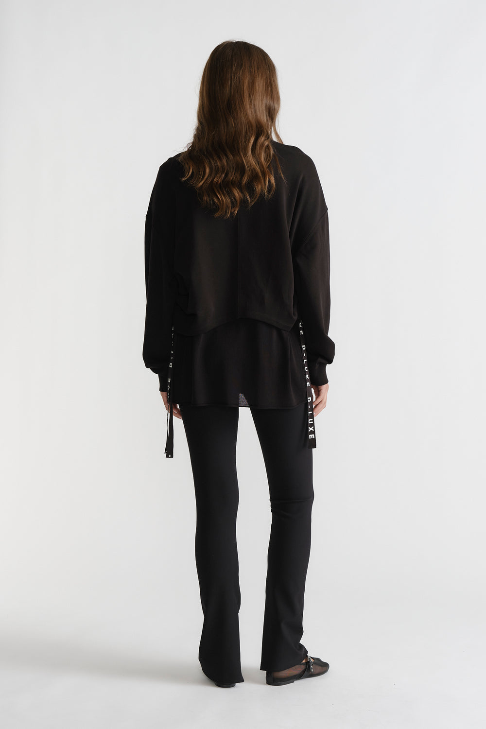 Back view of D-Luxe Ruched Terry Sweat in black with relaxed fit, styled with slim black pants and flats for sleek comfort.