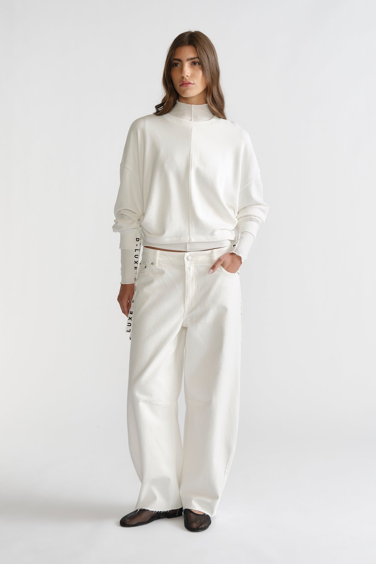 Woman dressed in ivory D-Luxe Ruched Terry Sweat with relaxed fit pants, featuring subtle ruching for a stylish casual look.