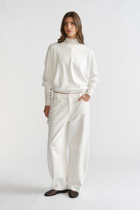 Woman dressed in ivory D-Luxe Ruched Terry Sweat with relaxed fit pants, featuring subtle ruching for a stylish casual look.