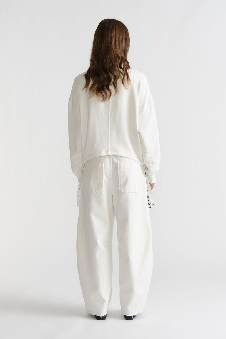 Back view of D-Luxe Ruched Terry Sweat in soft ivory with relaxed fit, styled with loose white pants for casual ease.