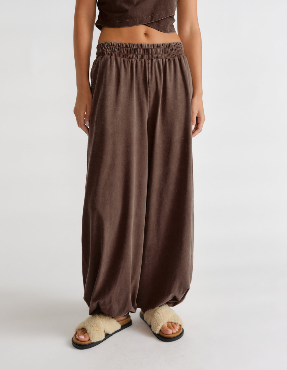 Woman wearing brown balloon joggers with an elasticated waist and hem 񟿿