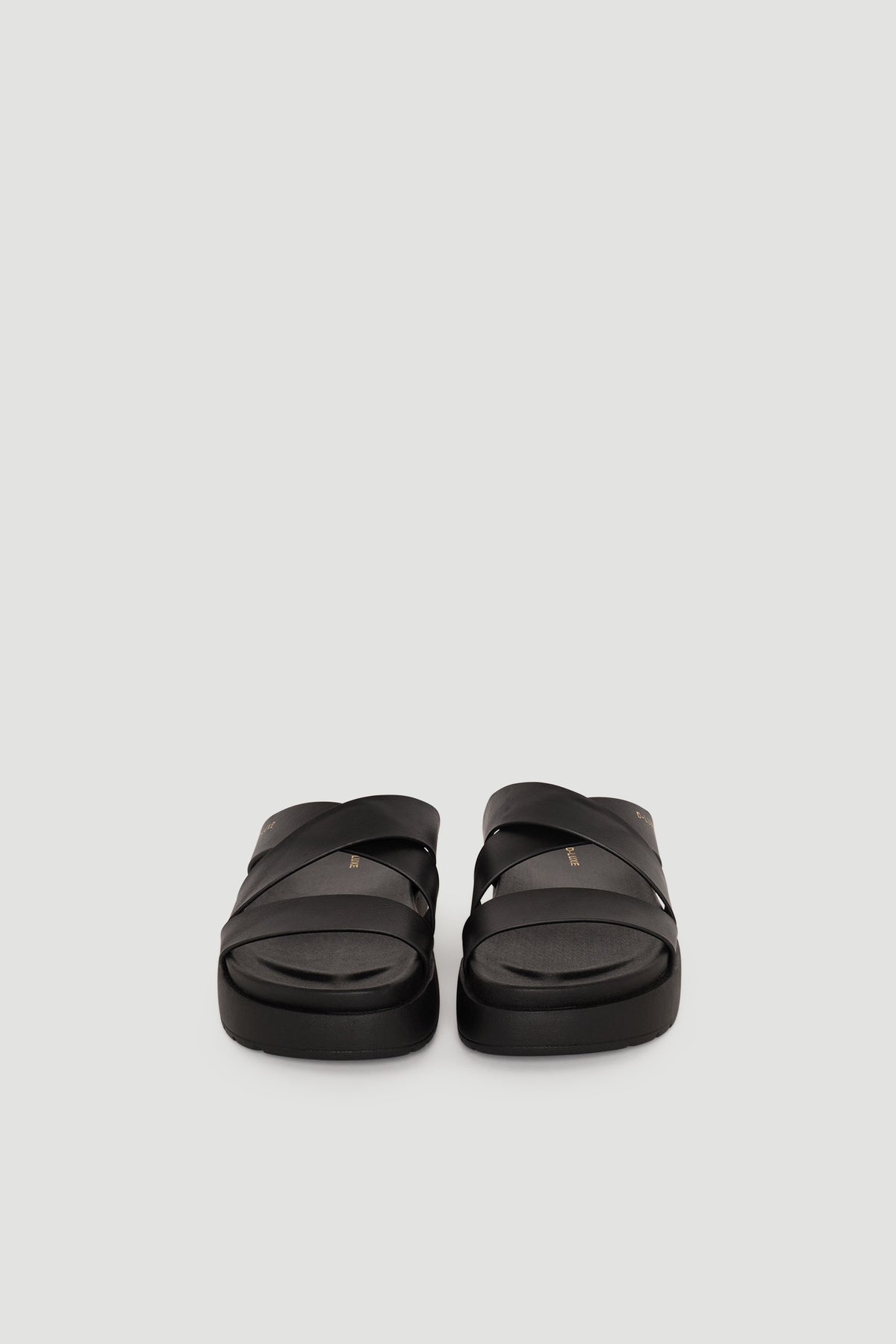 Pair of black leather slide sandals with wide crisscross straps and cushioned footbed for everyday comfort