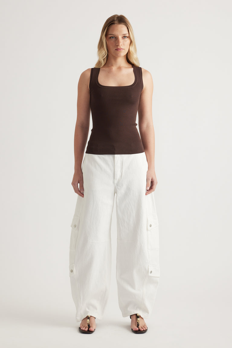 Woman wearing a brown square neck knit tank with white wide leg cargo pants and sandals