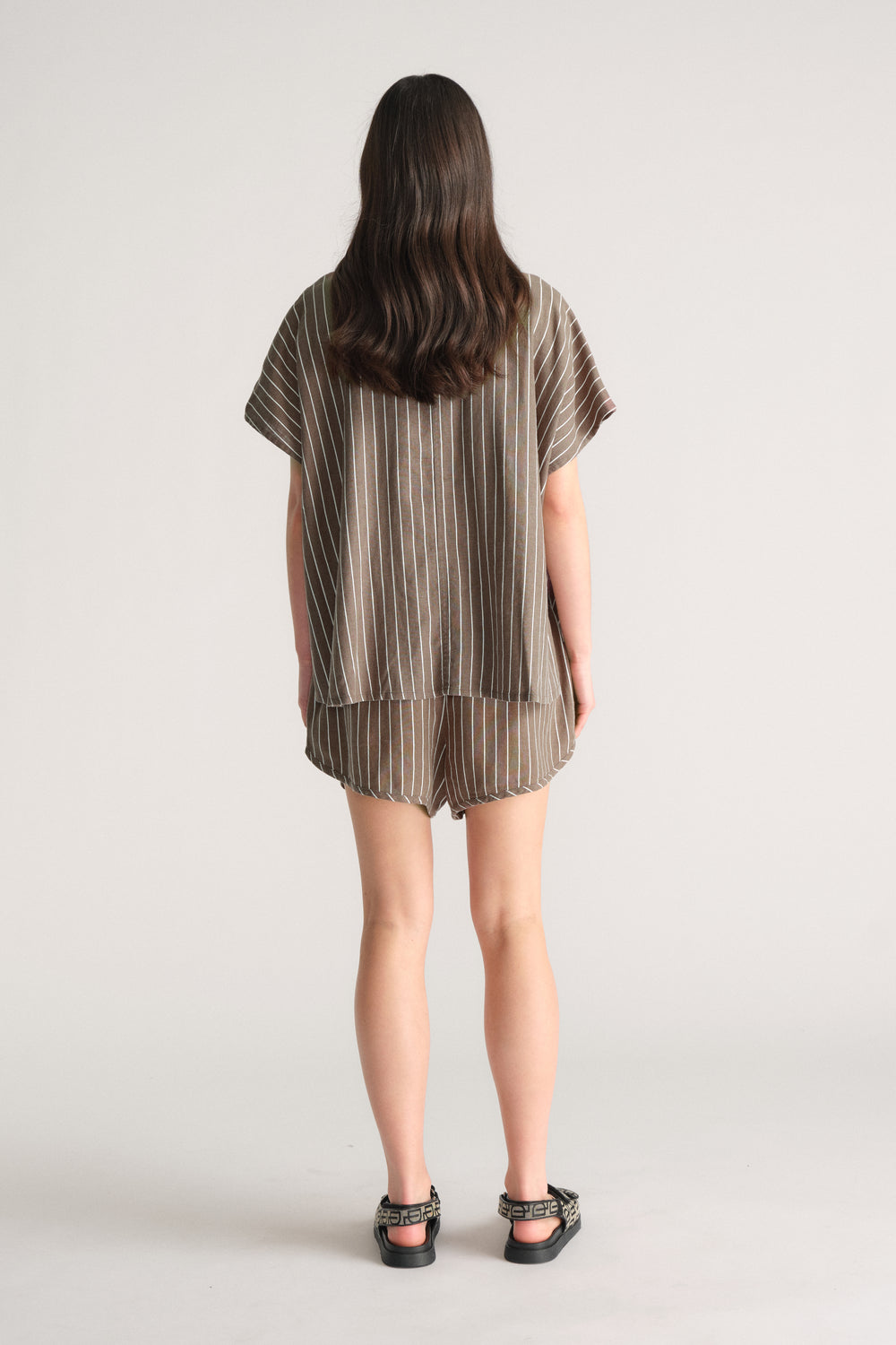 Back view of model wearing D-Luxe Linen Blend Curve Short in striped fabric, gallery image 3, portrait 4000x6000 pixels