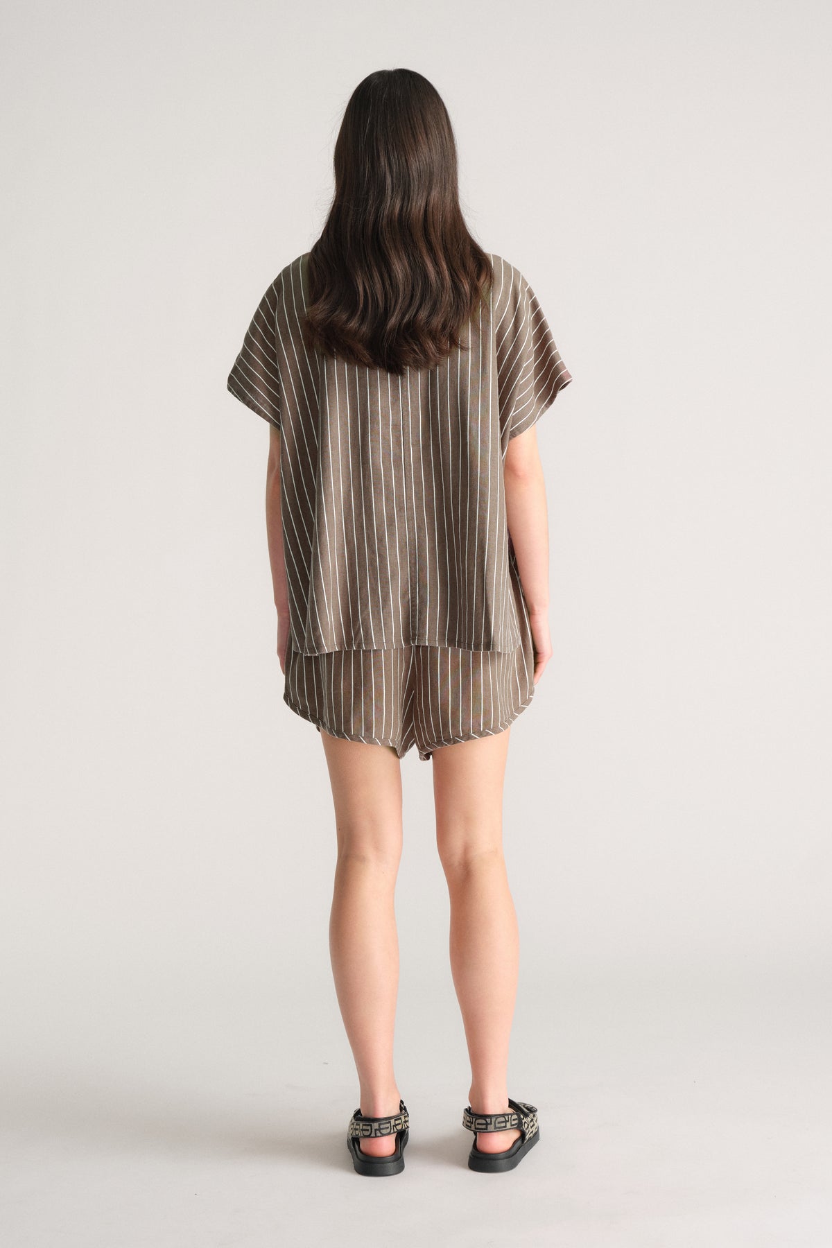 Back view of model wearing D-Luxe Linen Blend Curve Short in striped fabric, gallery image 3, portrait 4000x6000 pixels
