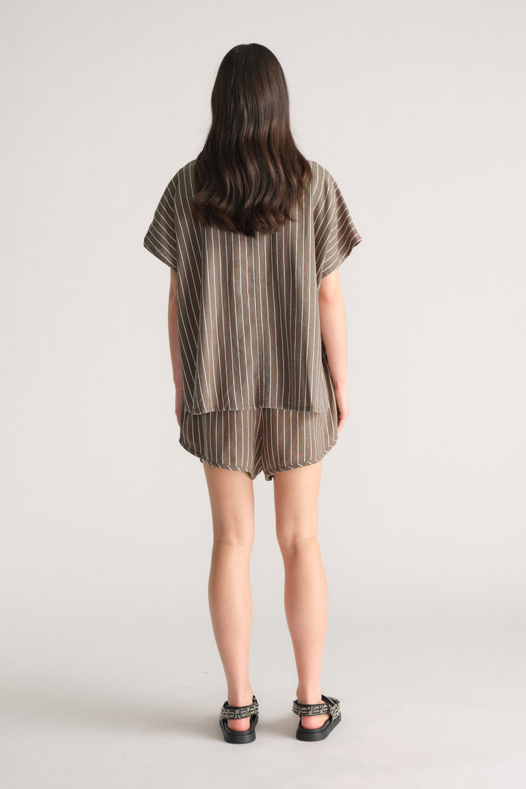 Back view of model wearing D-Luxe Linen Blend Curve Short in striped fabric, gallery image 3, portrait 4000x6000 pixels