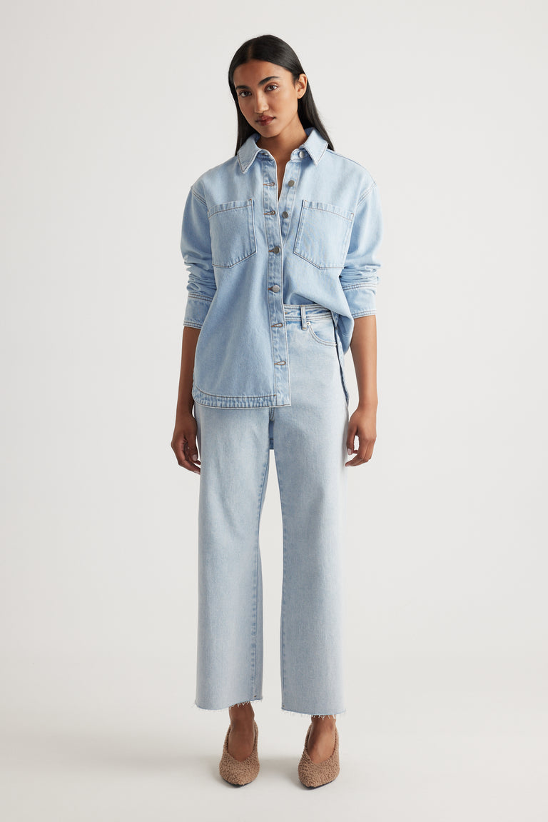 Woman wearing Tahni Wide Leg Jean in light denim with a relaxed fit paired with matching denim shirt by Decjuba Australian brand