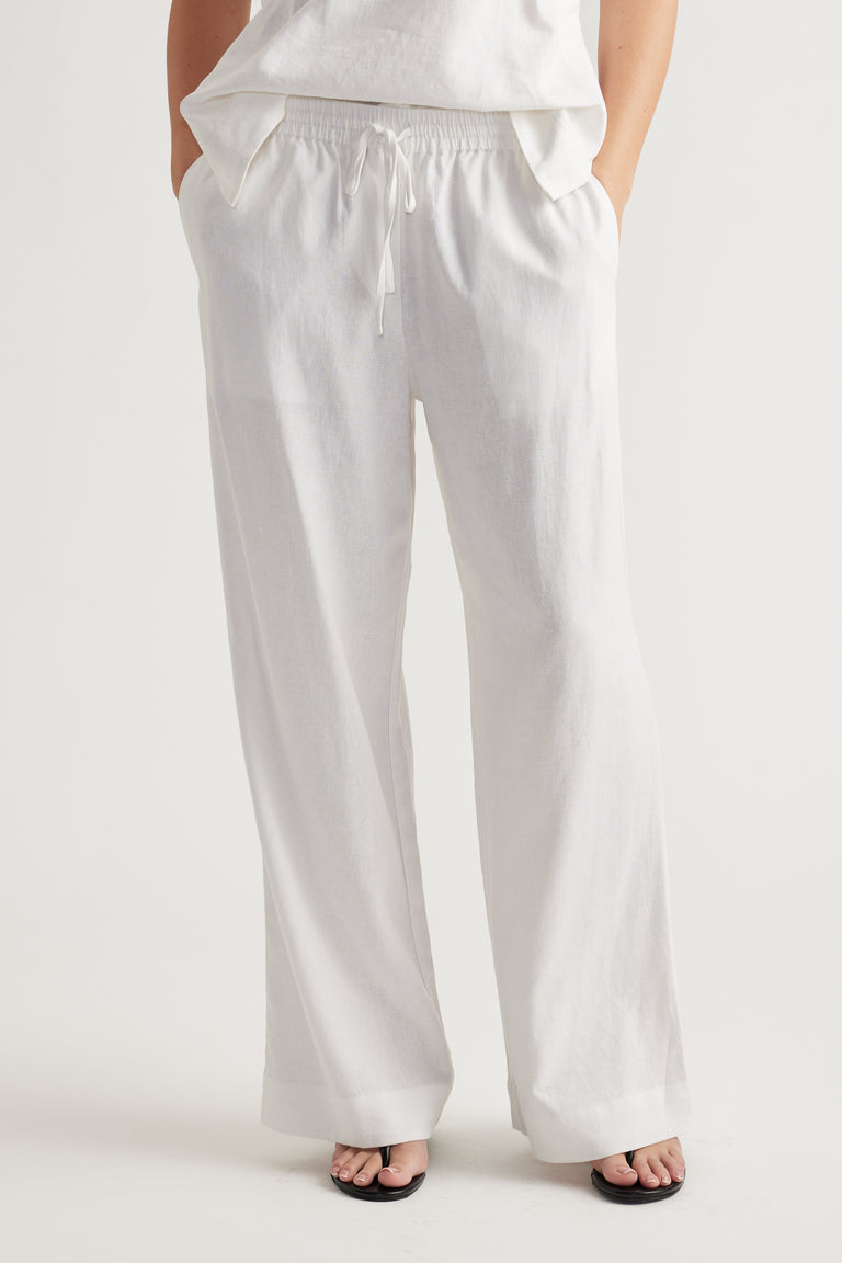 Relaxed white linen blend pants with elastic waistband and drawstring, styled for effortless everyday comfort.