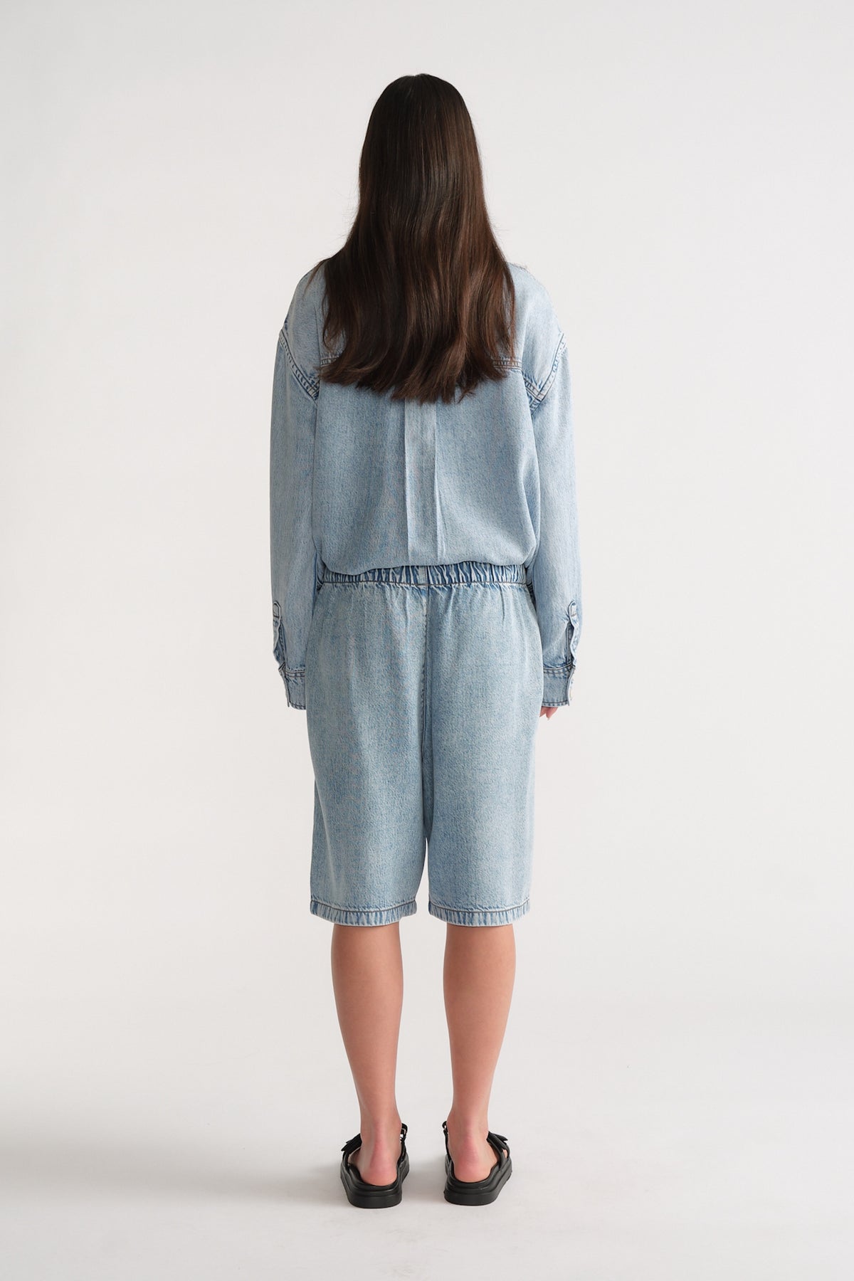 Back view of D-Luxe Fluid Denim Short in light denim with relaxed fit, styled effortlessly by Decjuba Australian fashion brand