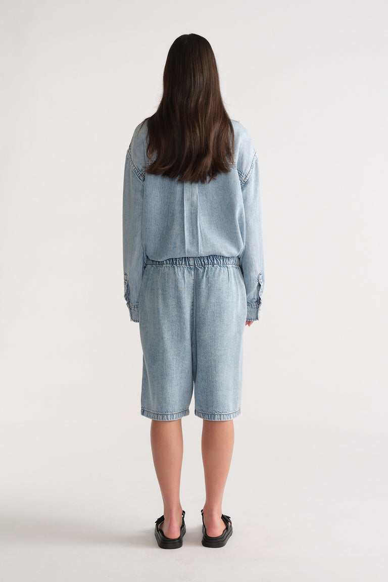 Back view of D-Luxe Fluid Denim Short in light denim with relaxed fit, styled effortlessly by Decjuba Australian fashion brand