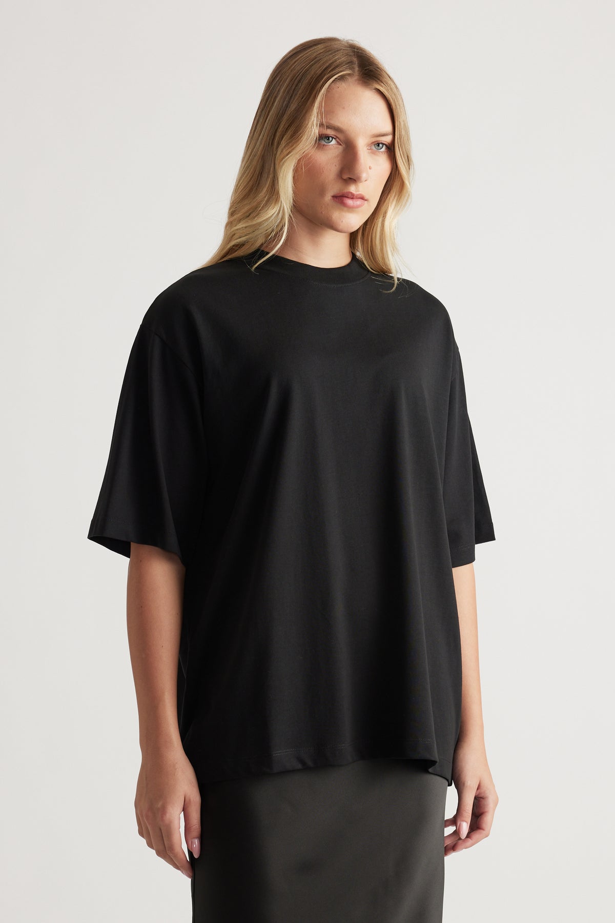Woman wearing a relaxed fit black oversized tee with short sleeves styled effortlessly for everyday wear