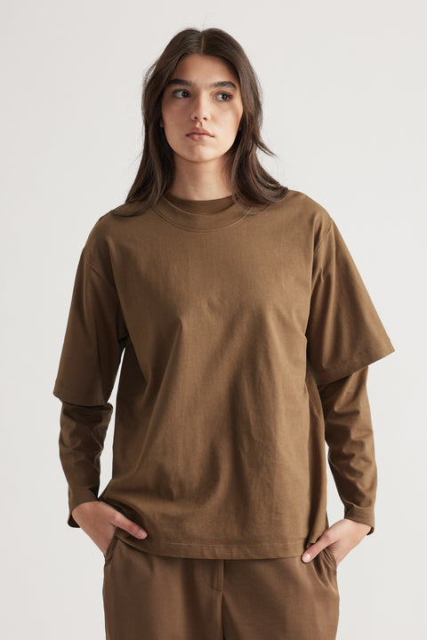 Woman wearing a relaxed-fit brown oversized tee styled over a matching long-sleeve top and pants for an effortless look