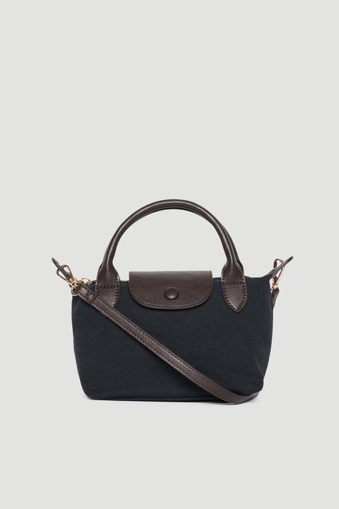 Black mini top handle bag with brown trim, double handles, flap closure and detachable crossbody strap