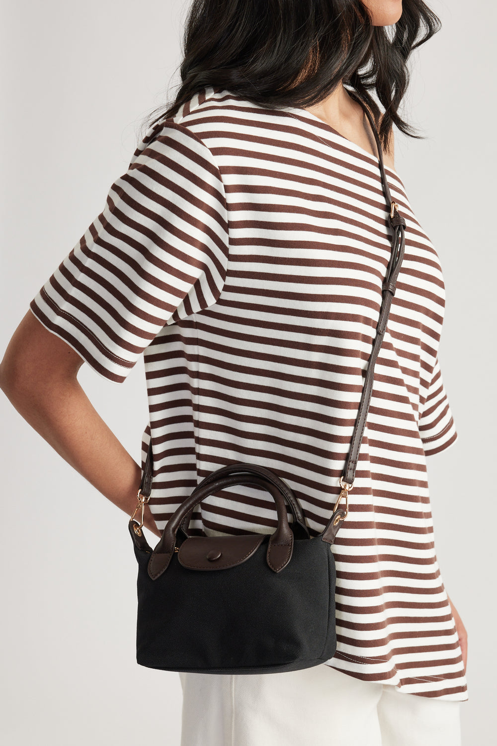 Black mini top handle bag worn crossbody with a detachable long strap and zip closure