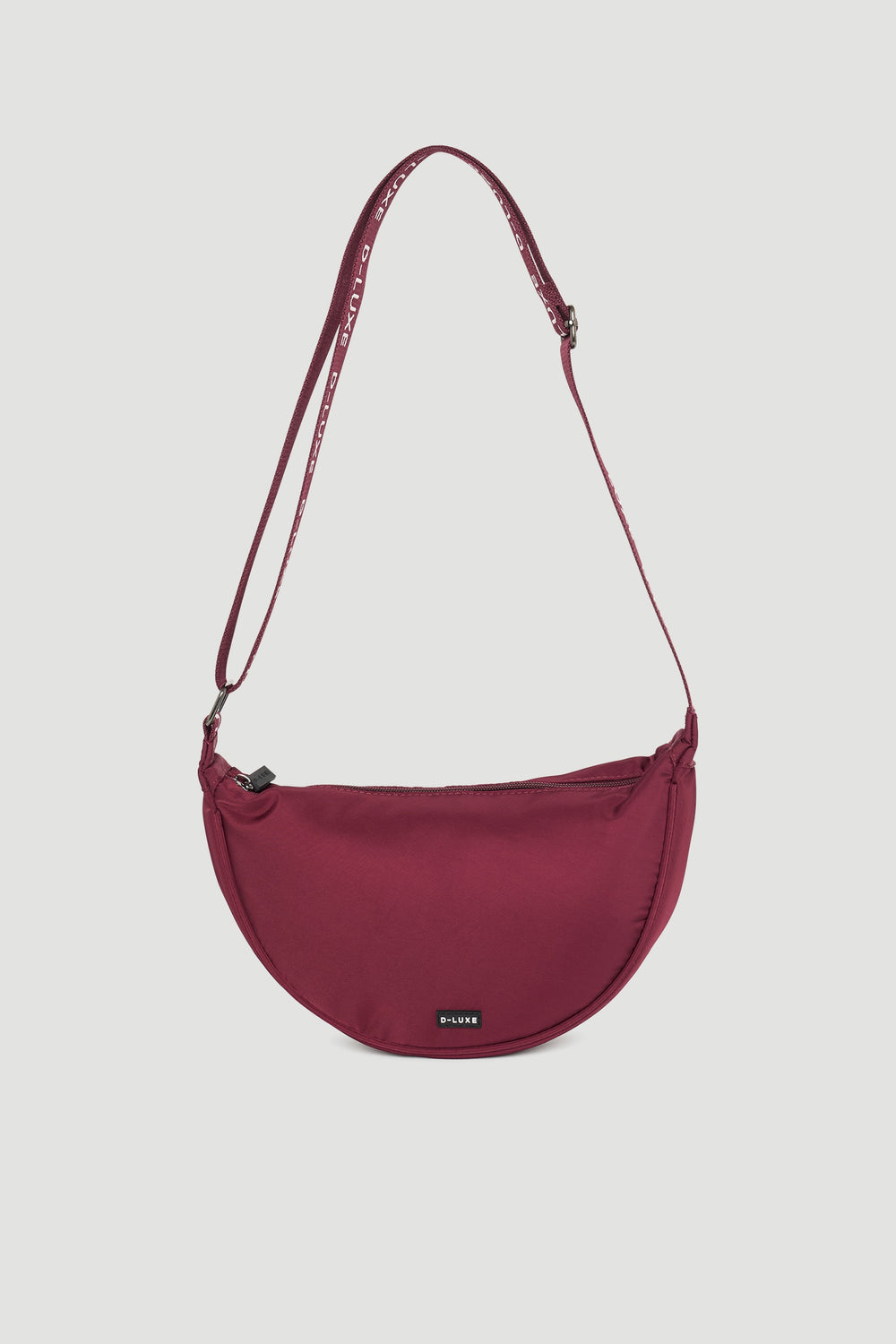 Plum half moon crossbody bag with adjustable branded strap and subtle logo detail on front panel